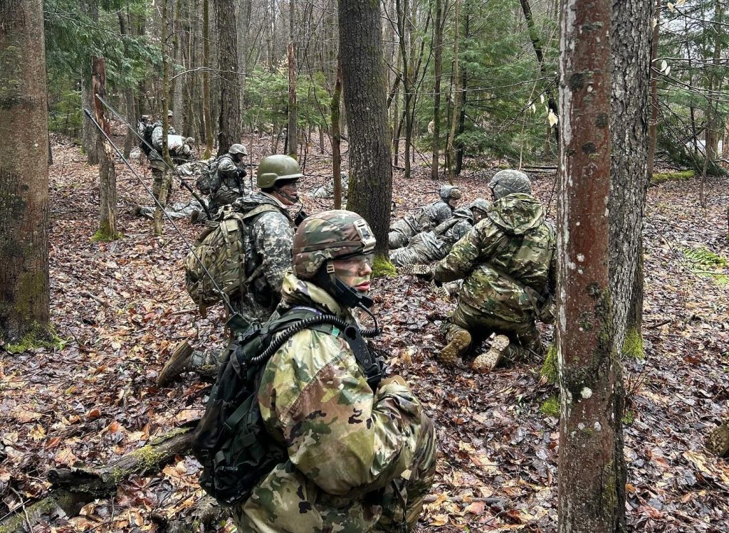 Prospective Students Cadets hiding in the woods with camouflage on
